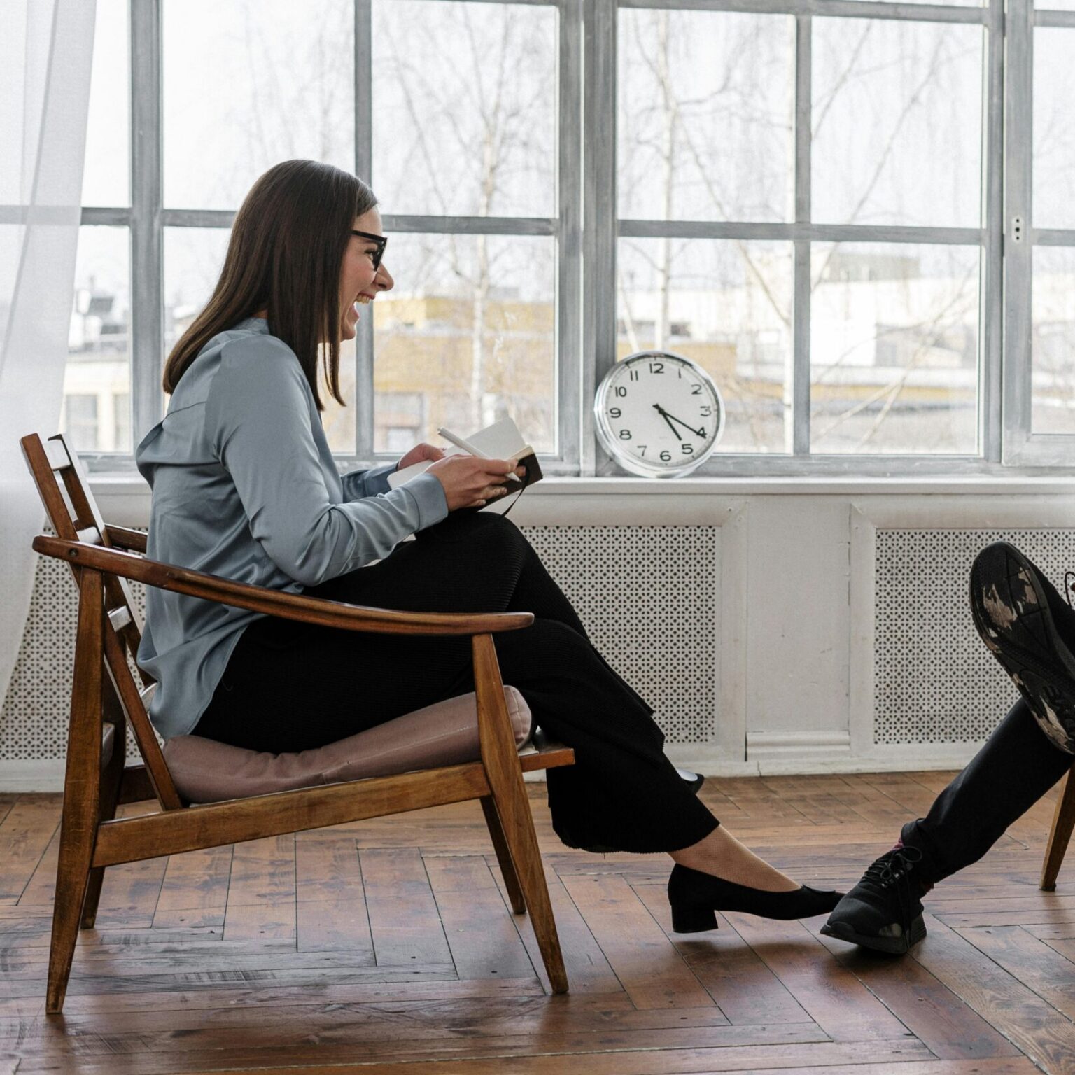 Counselor and client in a positive therapy session in a well-lit room.